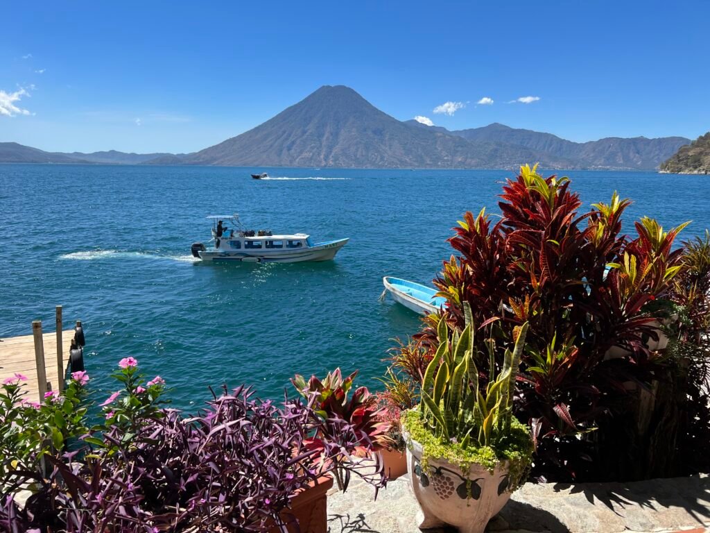 Lake Atitlan in the Guatemalan highlands, with a passenger boat crossing beneath a volcano